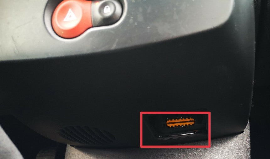 Emplacement de la prise de diagnostic OBD2 orange sur une Renault Clio 3 sous la console centrale