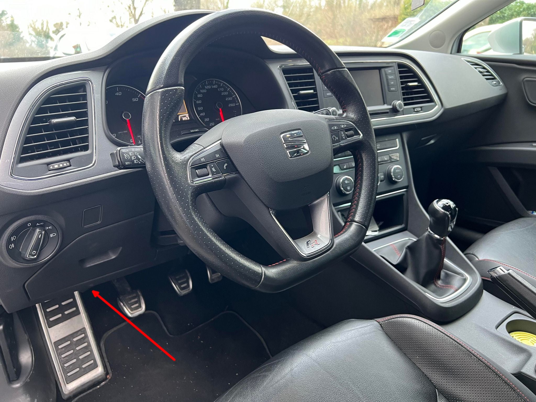 Une fleche rouge indique l emplacement de la prise OBD de diagnostic sous le tableau de bord d une Seat