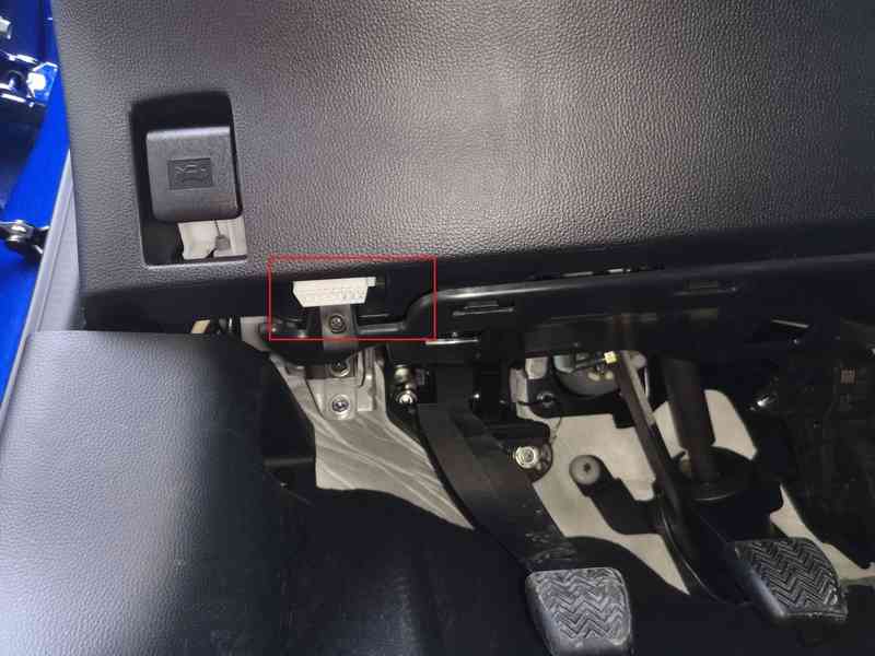 Emplacement de la prise de diagnostic OBD2 sous le volant d une Toyota Aygo X