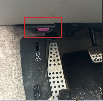 Prise de diagnostic OBD2 violette sous le tableau de bord d une voiture