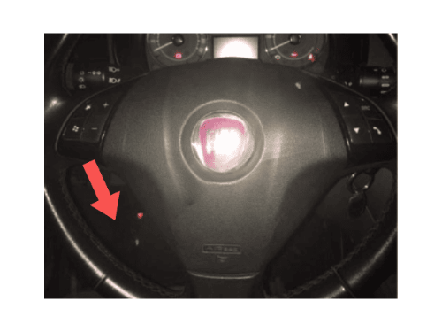 Flèche rouge montrant l emplacement de la prise OBD derrière le volant d une Fiat Linea