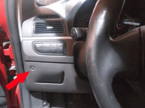 Emplacement de la vis du tableau de bord sur une Fiat Punto 3 indiqué par une flèche