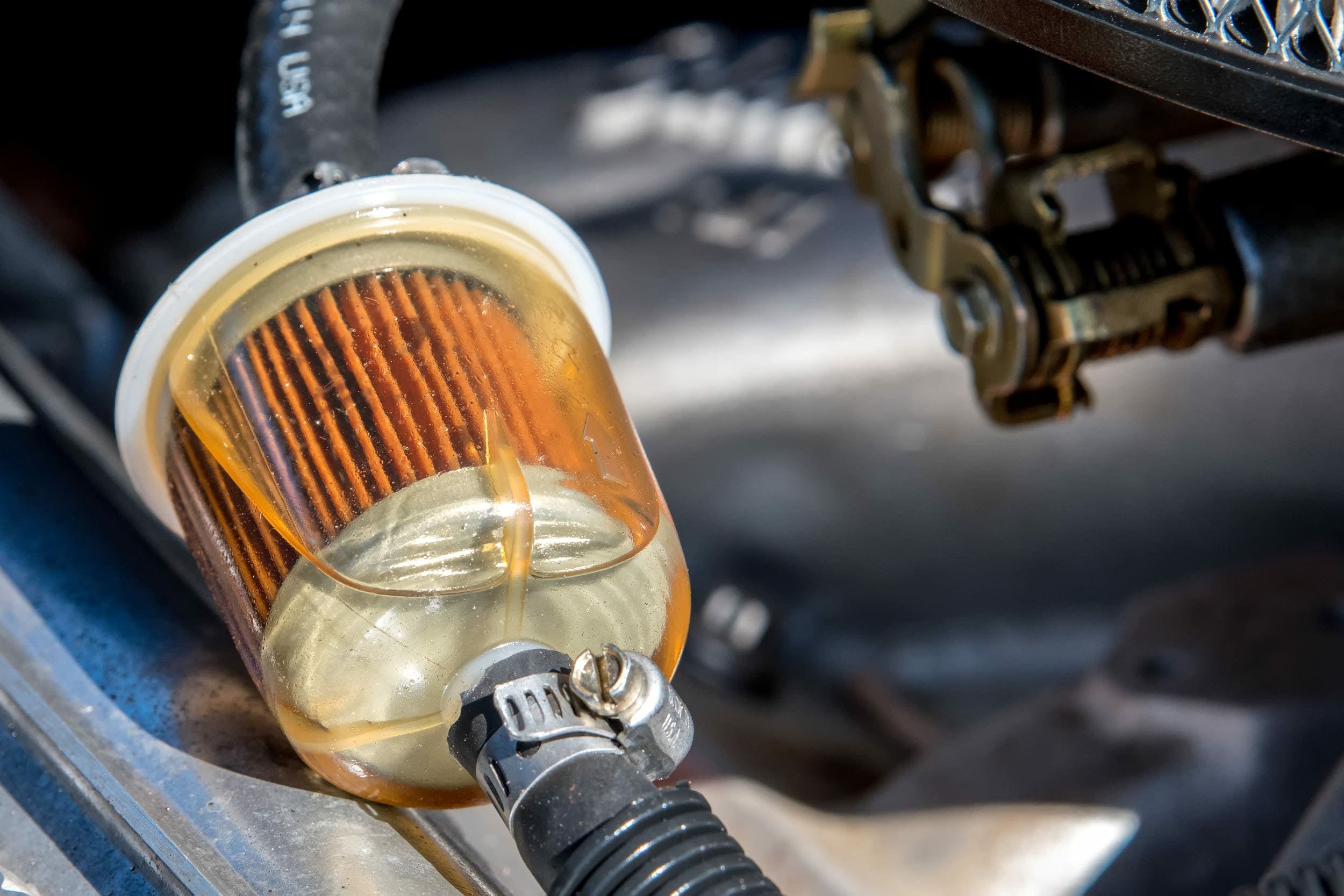 Gros plan sur un filtre a carburant transparent rempli d essence sous le capot d une voiture