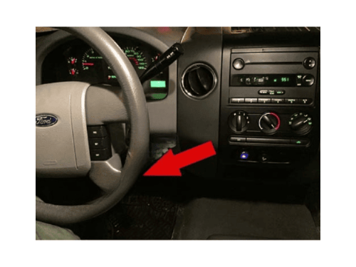 Tableau de bord et volant d un Ford F150 avec flèche rouge indiquant l emplacement de prise OBD