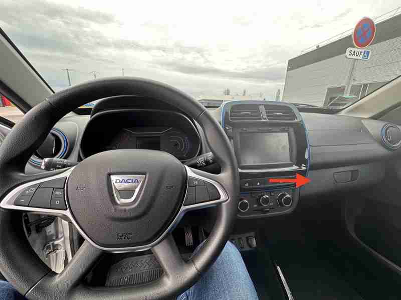 Vue intérieure de l'habitacle d'une Dacia Spring avec focus sur les boutons de la console