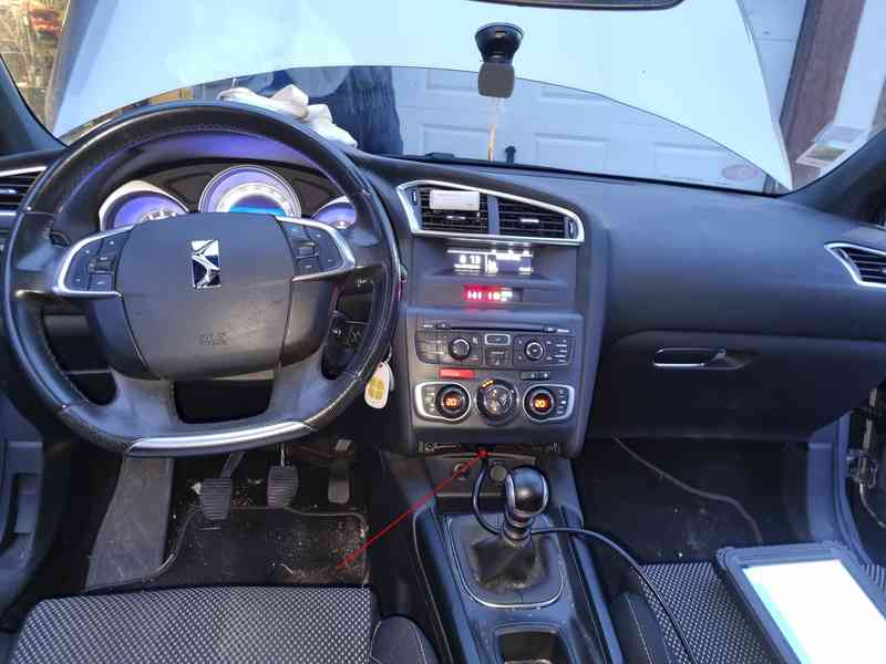Vue de l habitacle d une DS4 Crossback avec une fleche montrant l emplacement de la prise OBD