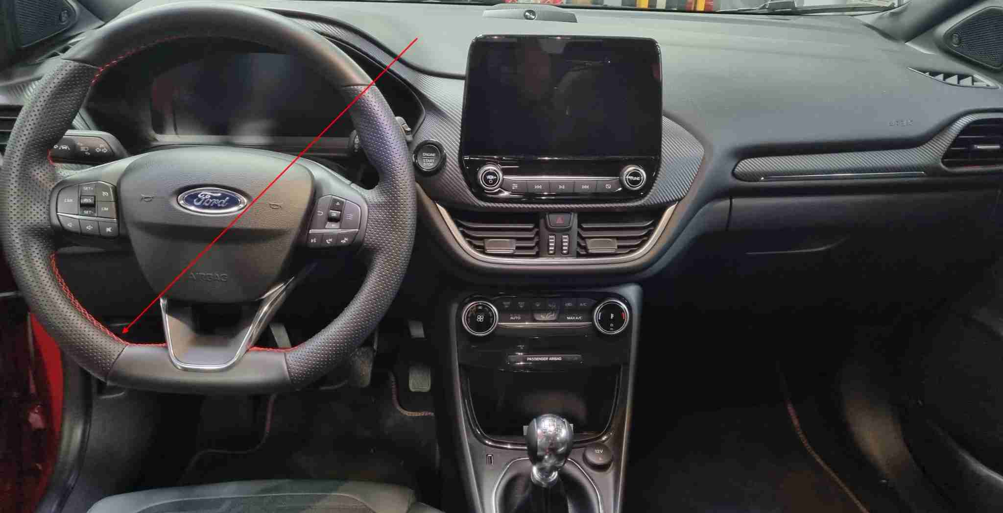 Vue de l'habitacle d'une Ford Puma avec volant sport et écran central pour diagnostic OBD2