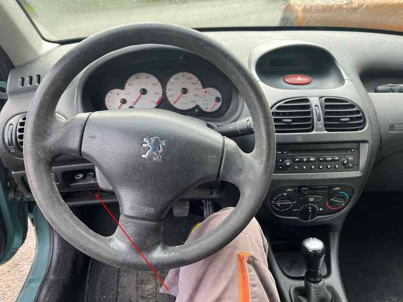 Vue de l'habitacle d'une Peugeot 206 SW indiquant l'emplacement de la prise OBD