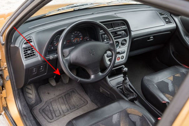 Une flèche rouge indique l'emplacement de la pédale d'embrayage dans une Peugeot 306