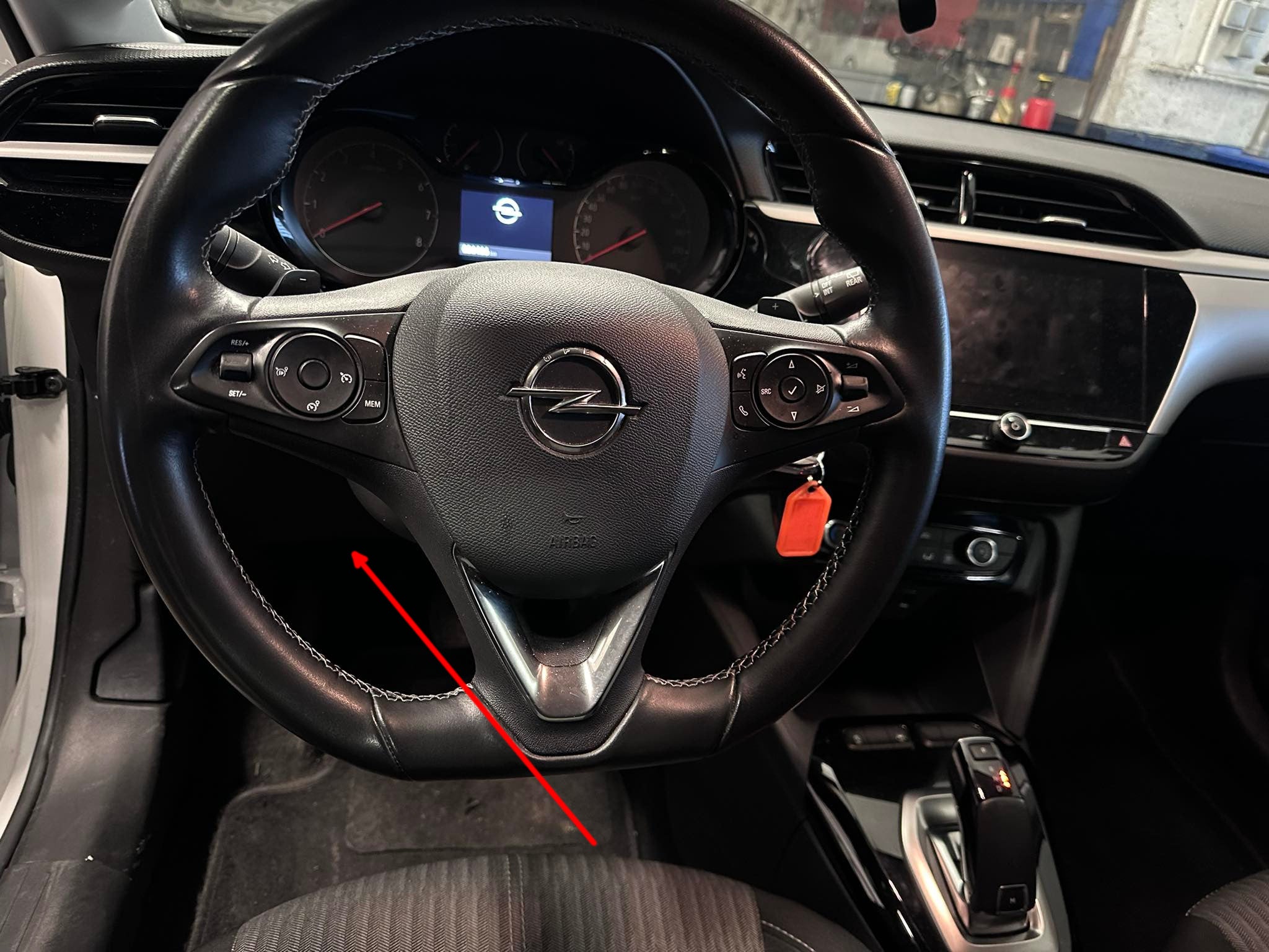 Emplacement de la prise OBD sous le volant d'une Opel Corsa pour diagnostic