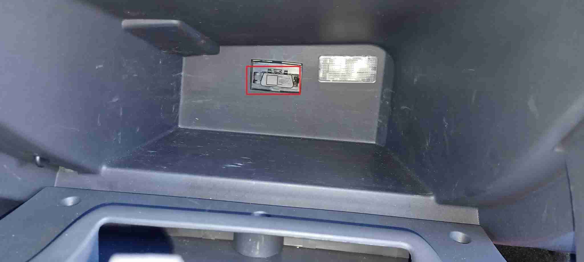 Emplacement de la prise OBD2 encadré en rouge dans la boîte à gants d'une Dacia Logan II