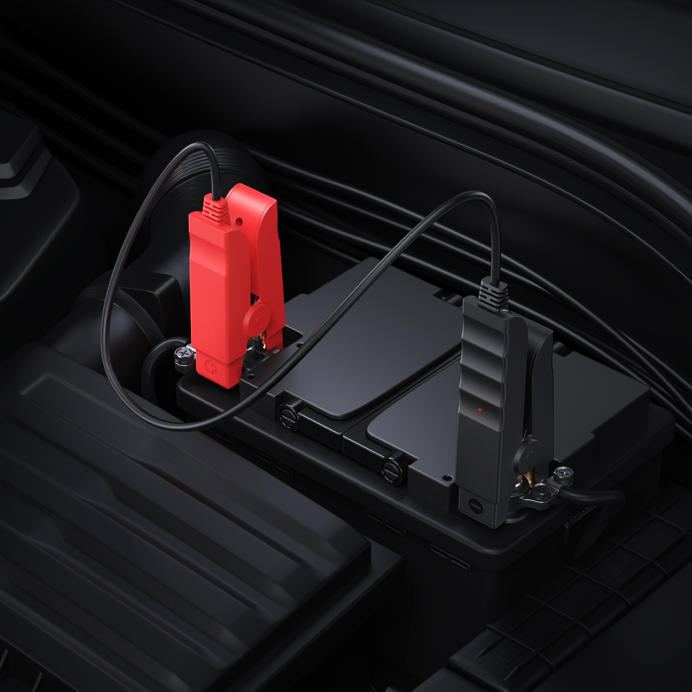 Pinces de démarrage rouge et noire branchées sur une batterie de voiture
