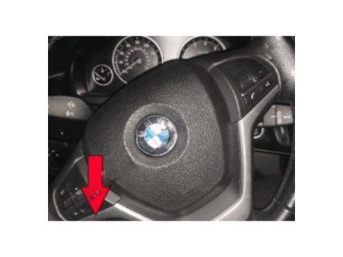 Gros plan sur les commandes au volant d une BMW X5 F15 avec une fleche rouge